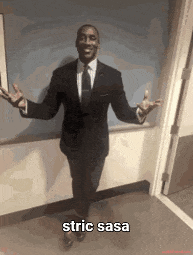 a man in a suit and tie is standing in a hallway with his arms outstretched with the caption strict sasa
