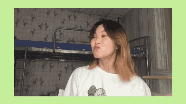 a girl wearing a white shirt with a kaws logo on it