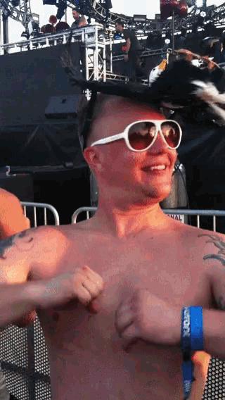 a shirtless man wearing sunglasses and a blue wristband that says ' ucsd '