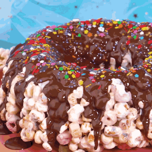 a chocolate covered cake with popcorn and sprinkles