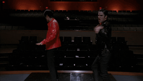 a man in a sequined jacket with a red bow tie stands next to another man in a red jacket