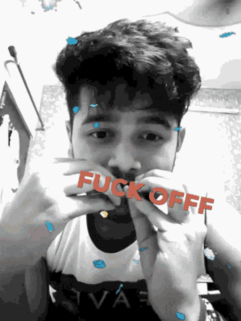 a black and white photo of a young man with the word fuck off written on his face