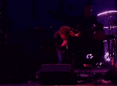a man is playing a guitar in front of a vox amp
