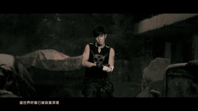 a man wearing boxing gloves and a black tank top with chinese writing