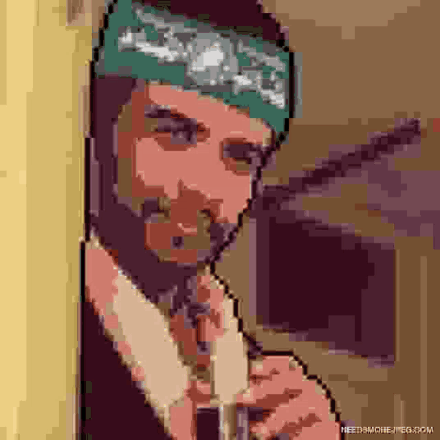 a man with a beard is smoking a cigarette while wearing a bandana .