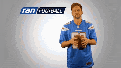 a man in a chargers jersey holds a football in his hands