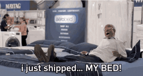a man is laying on a bed with the words " i just shipped my bed "