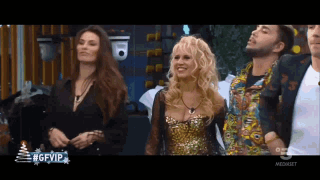 a group of people are standing next to each other in front of a sign that says #gfvip .