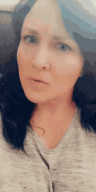 a woman with a nose ring is making a funny face
