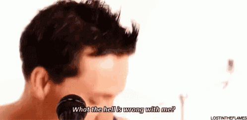 a man is singing into a microphone and saying what the hell is wrong with me .