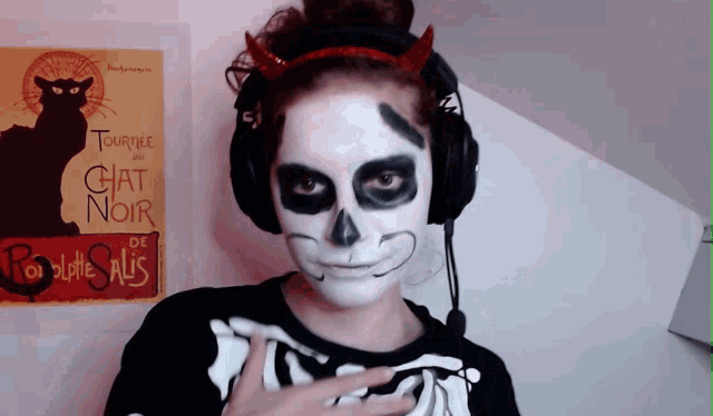 a woman in a skeleton costume stands in front of a poster that says " chat noir "