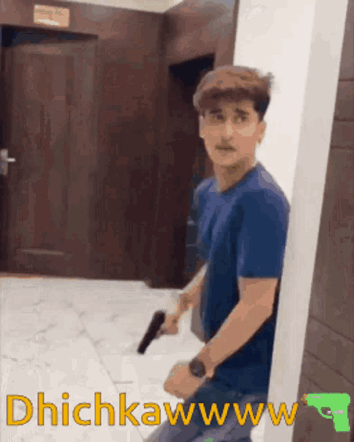 a man in a blue shirt is holding a gun in a hallway with the words dhichkawww written on the bottom