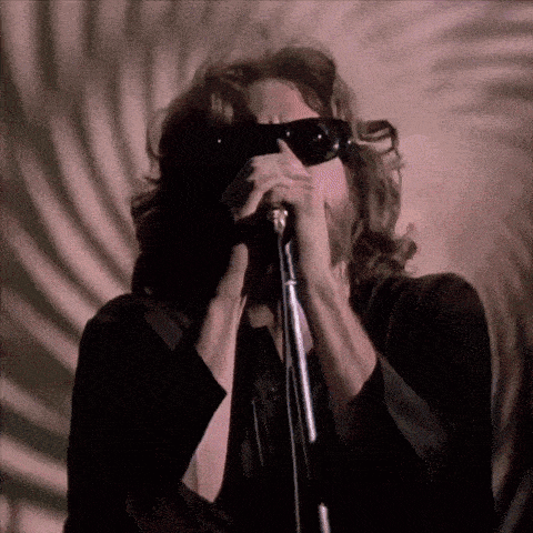 a man singing into a microphone with his eyes closed