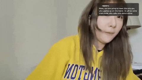 a woman wearing a yellow hoodie is sitting in front of a computer screen .