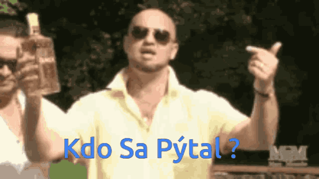 a man holding a bottle with the words kdo sa pytal written on it