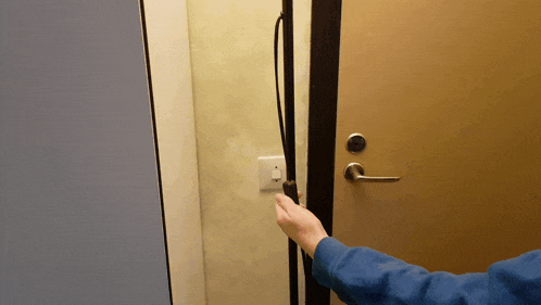 a person opens a door with the letter l on the handle