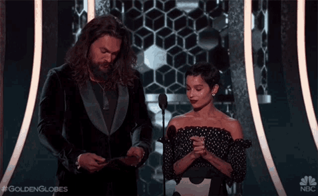 a man and a woman on a stage with the words golden globes on the bottom