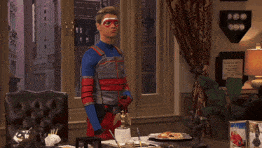 a man in a superhero costume stands in front of a desk