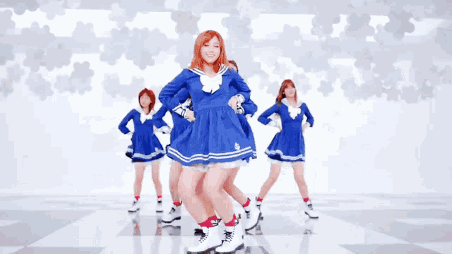 a group of girls in blue and white uniforms are dancing