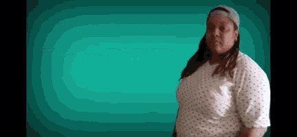 a woman in a hospital gown is standing in front of a blue background .