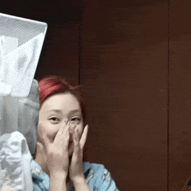 a woman with red hair covering her face with her hand