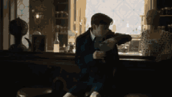 a man is pouring a drink into a glass while a woman looks on