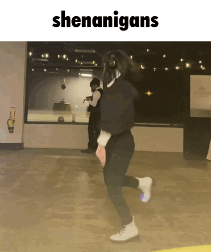 a woman is dancing in a room with the word shenanigans on the bottom