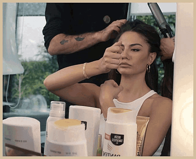 a woman is getting her hair done in front of a bottle that says pantene
