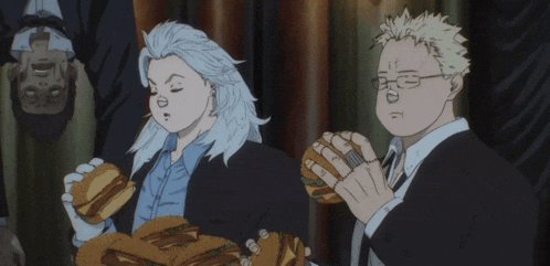a man and a woman are eating hamburgers and one of them has a ring on his finger