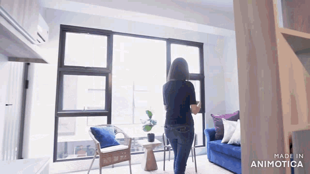 a woman is standing in a living room with the words made in animotica at the bottom