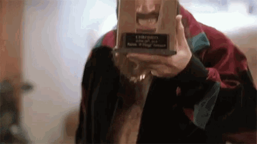 a man with a mustache is holding a trophy that says ' christmas ' on it