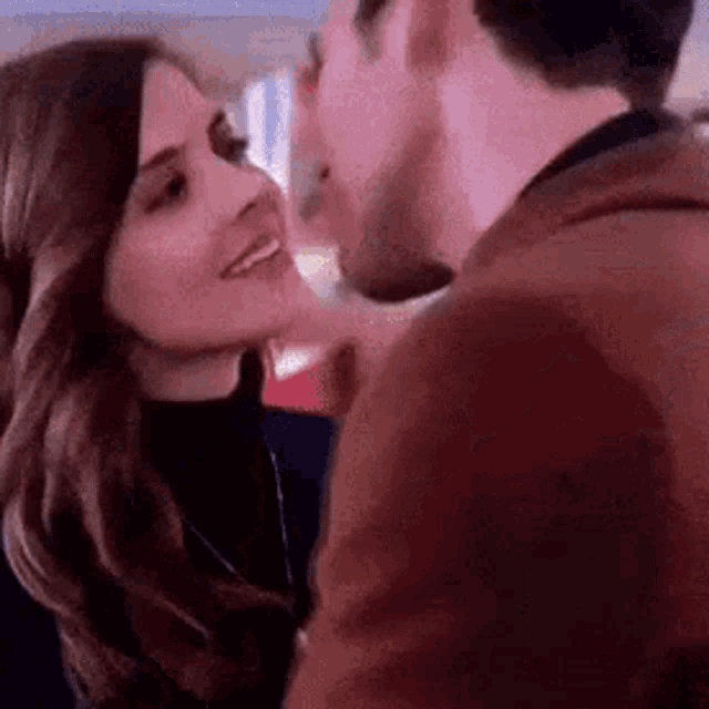 a man and a woman are kissing each other .