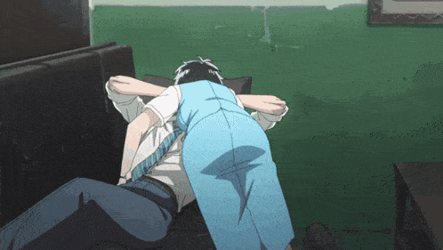 a man is laying on a couch with his arm around another man 's waist