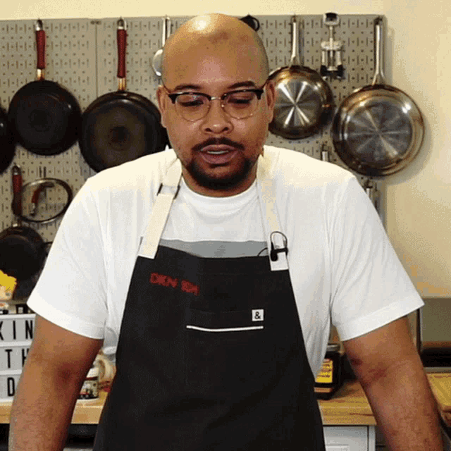 a man wearing glasses and an apron that says dixon