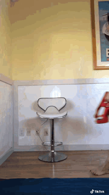 a white chair in a room with a picture on the wall that says e.