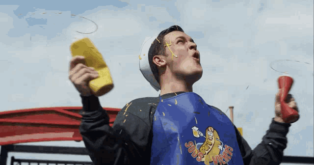a man wearing a blue apron that says super hot dogs on it