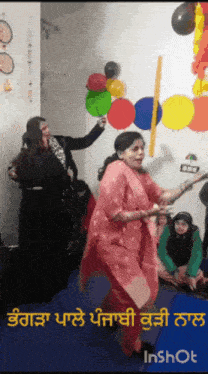 a woman in a pink dress is dancing in a room with balloons and the words inshot below her