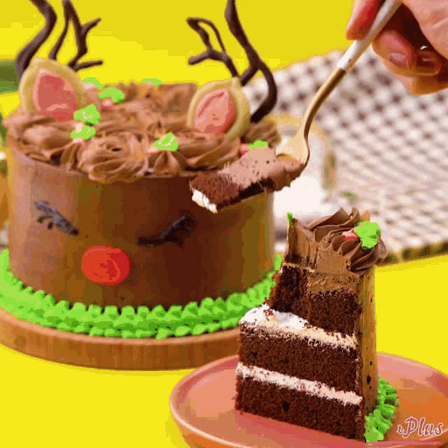 a person is taking a slice of cake from a cake decorated like a reindeer