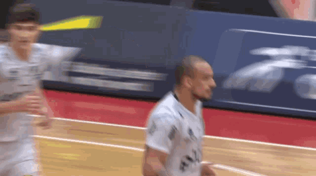 a blurry picture of two basketball players one of whom is wearing a jersey that says ' allianz ' on it