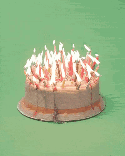 a birthday cake with lots of lit candles on it