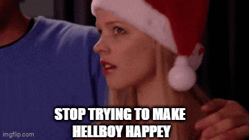 a woman wearing a santa hat says `` stop trying to make hellboy happy '' .