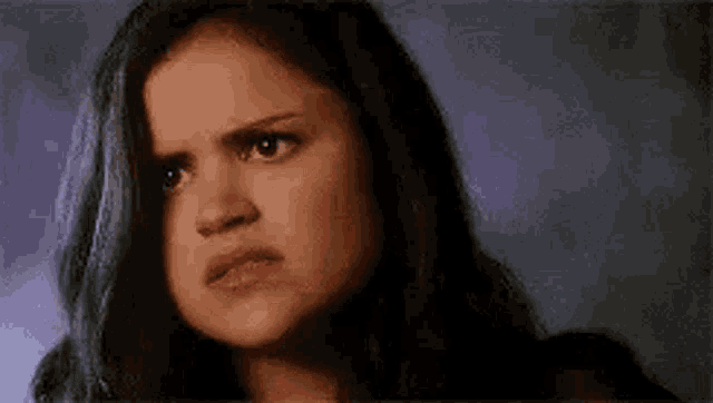 a close up of a woman 's face with an angry expression .