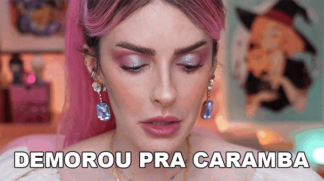a woman with pink hair is wearing earrings and has the words demorou pra caramba on her face