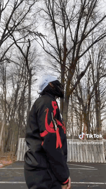 a person wearing a black jacket with a dragon on it