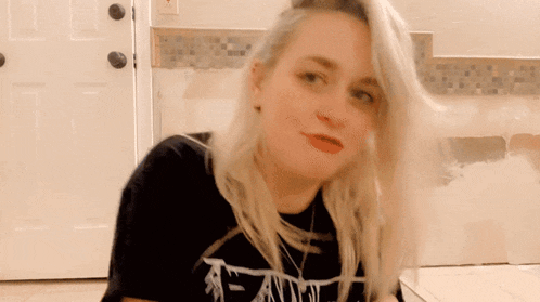 a woman with blonde hair is wearing a black shirt that says death