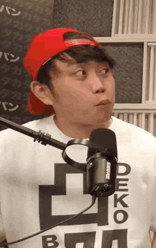 a man wearing a shure microphone and a shirt that says deko on it