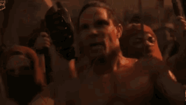 a group of men are holding swords in their hands and one of them is screaming .