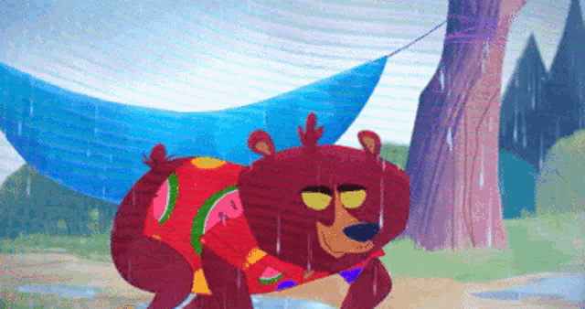 a cartoon bear wearing a watermelon shirt is laying in a hammock .