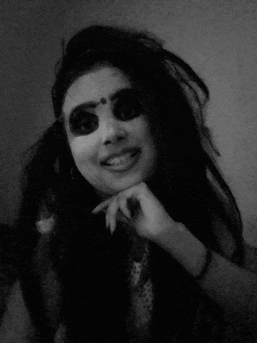 a woman with a bindi on her forehead is smiling