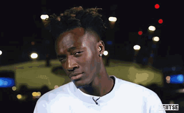 a man wearing a white sweatshirt with the word heitse on it